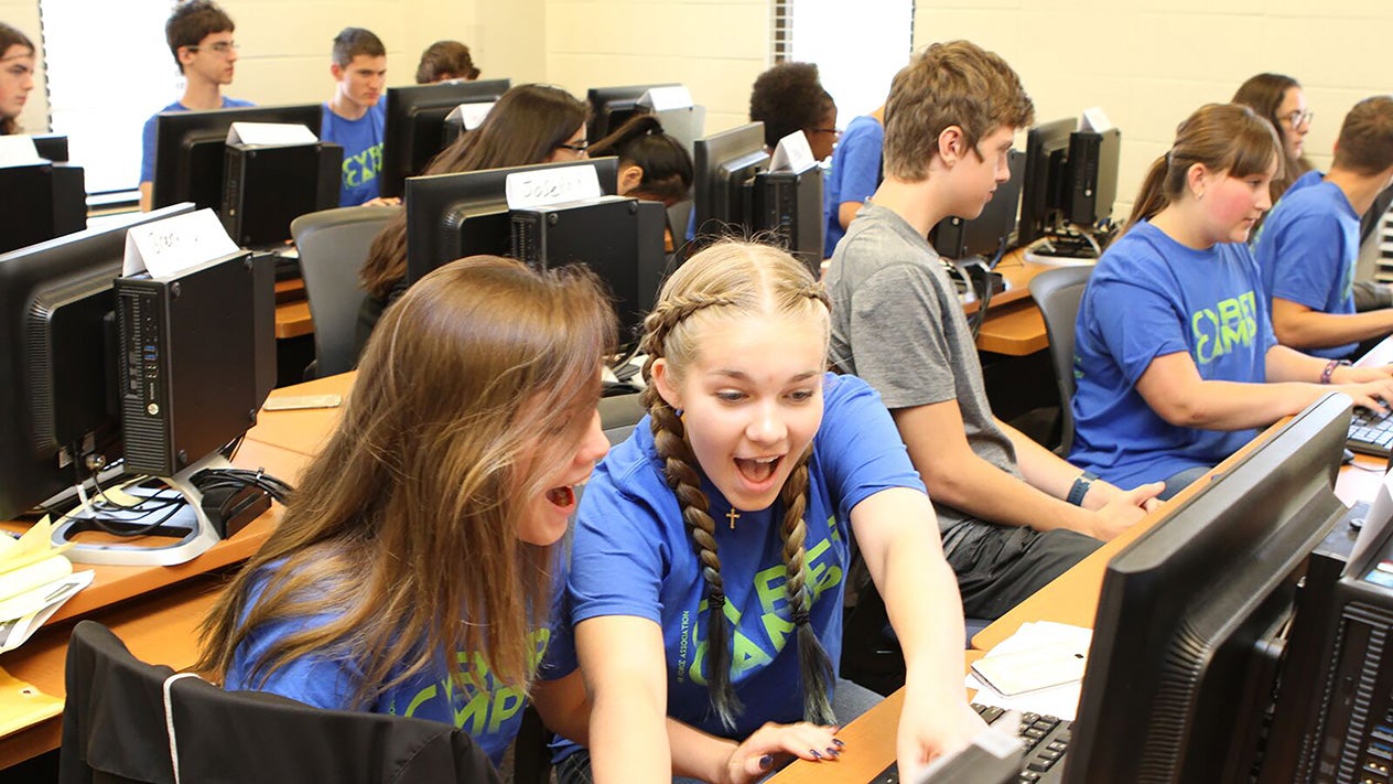 Students engaged in computer learning in a vibrant classroom.