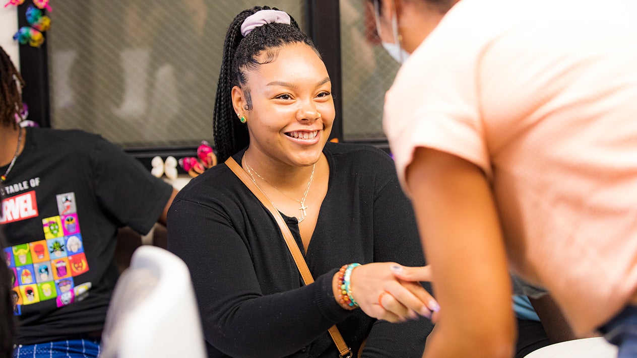 A woman happy and shaking hands with another woman