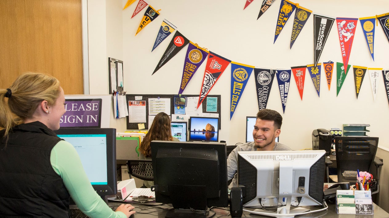 A Transfer Office staff person works with a student.