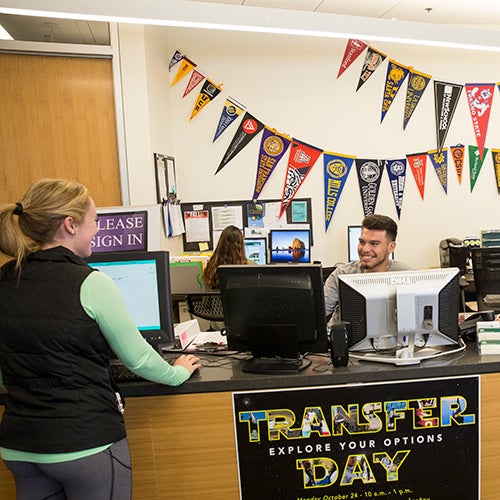 A Transfer Office staff person works with a student.