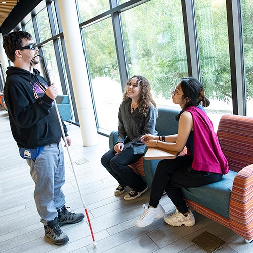 A blind DVC student talks with other students.