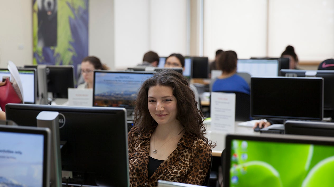 A student working on a computer in a computer lab