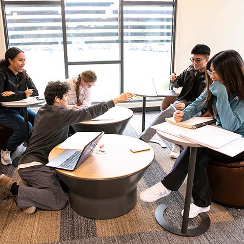 Group of students sitting around in a room chatting and discussing