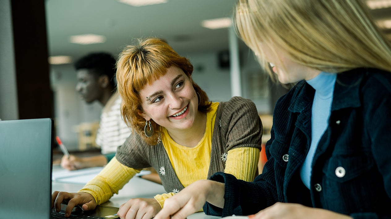 A DVC student works with a staff member.