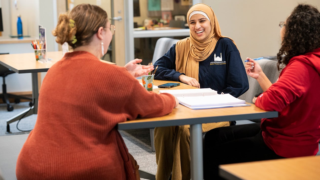 Diverse female students talking in classroom