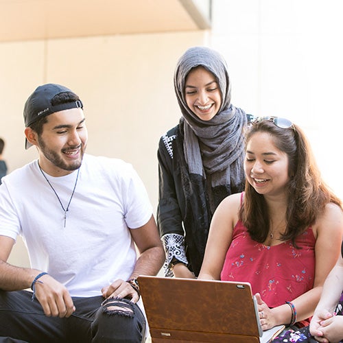 DVC students gathered around laptop