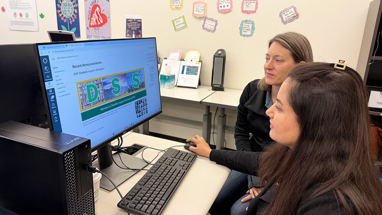 A DSS staff member helps a student in the High Tech Center.