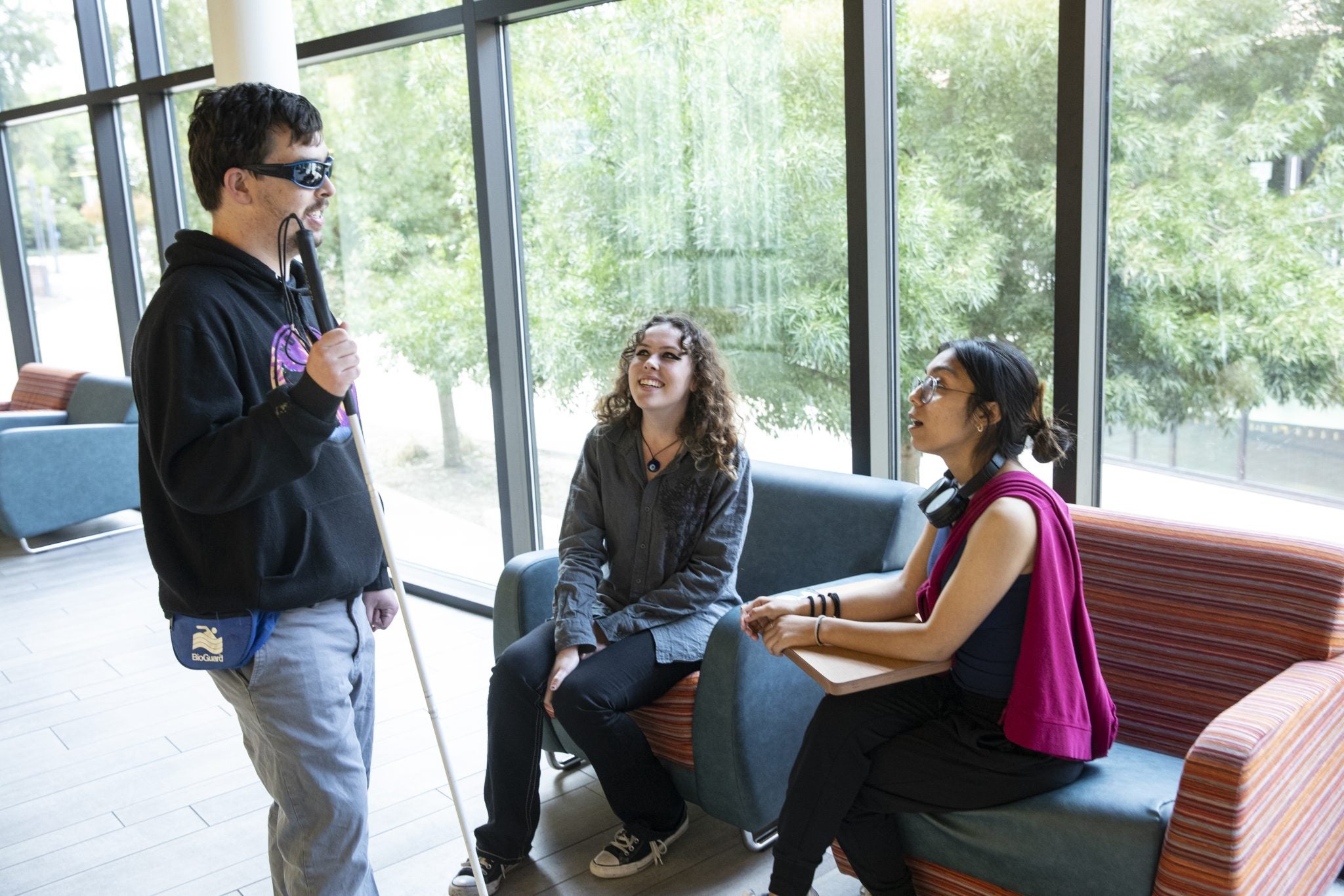 Visually-impaired student talking with other students on the DVC campus