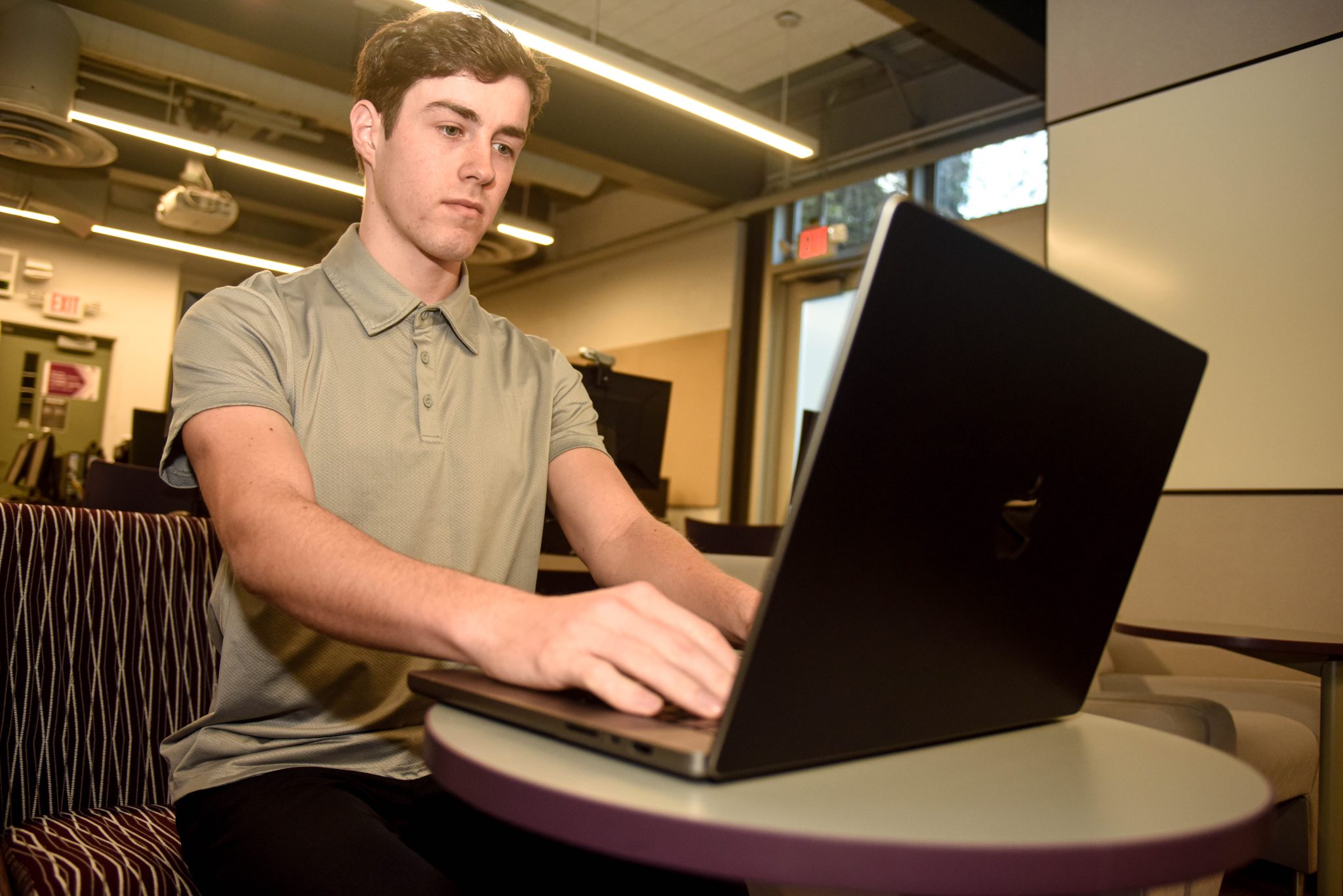 DVC community education and IBM cybersecurity student Justice Gaines working on his laptop