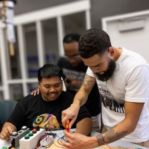 Male students working on electronics