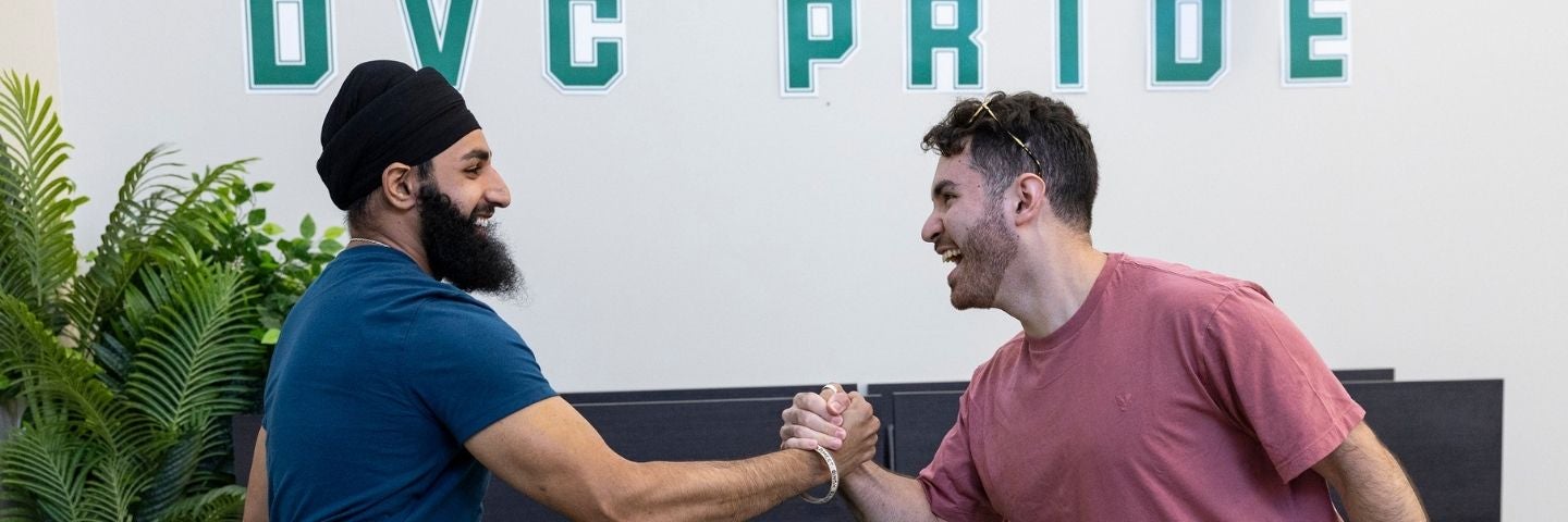 Two students clasping hands in celebration